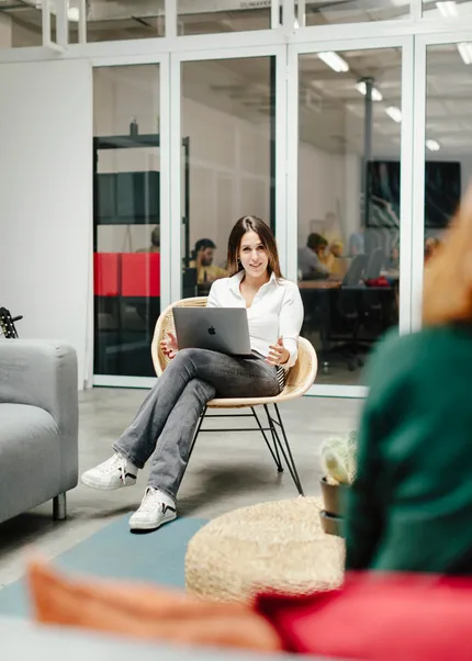 The Head of People seated with her laptop, engaged in conversation with the VP of product at Z1.